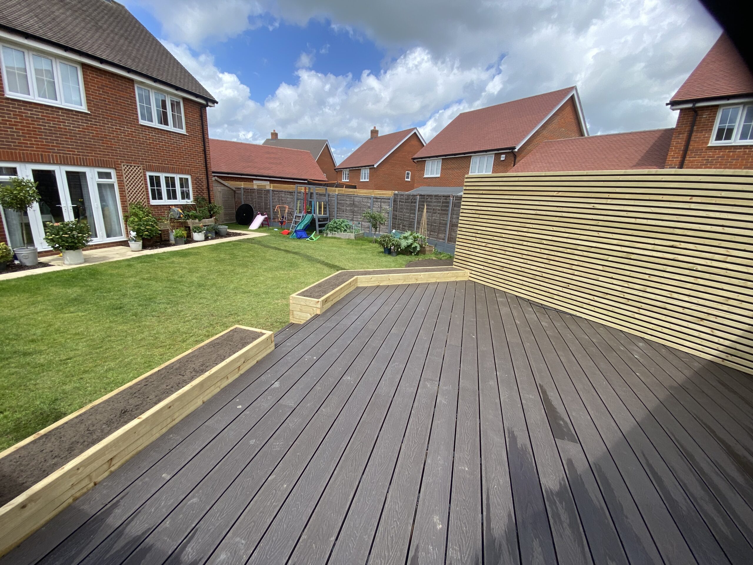 Composite decking with slatted privacy screen overlooking the garden