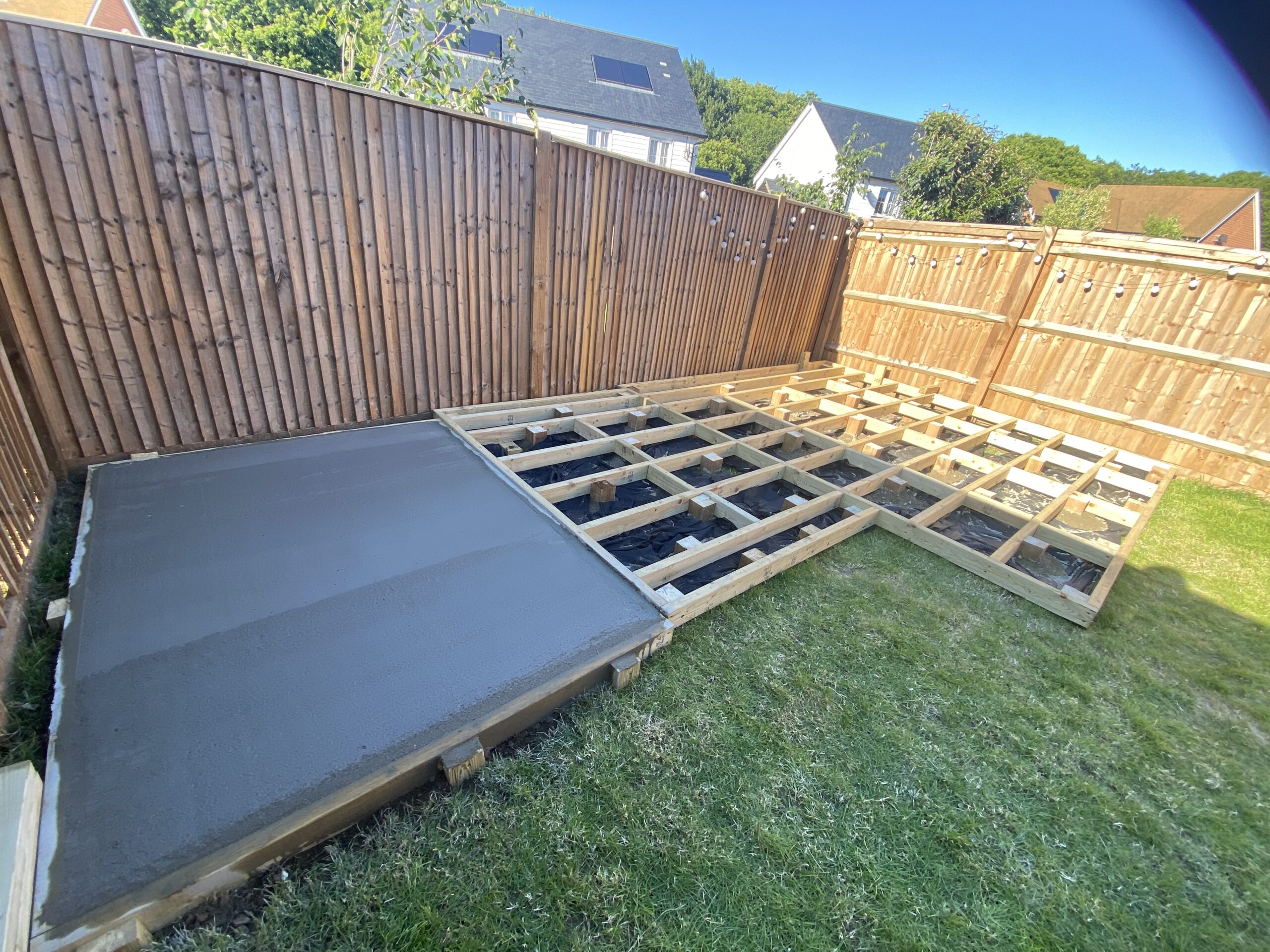 Fresh concrete base beside timber framework in a garden