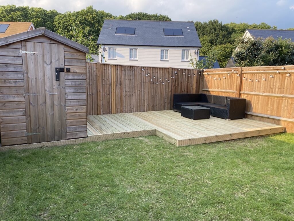 Raised timber decking seating area in a family garden