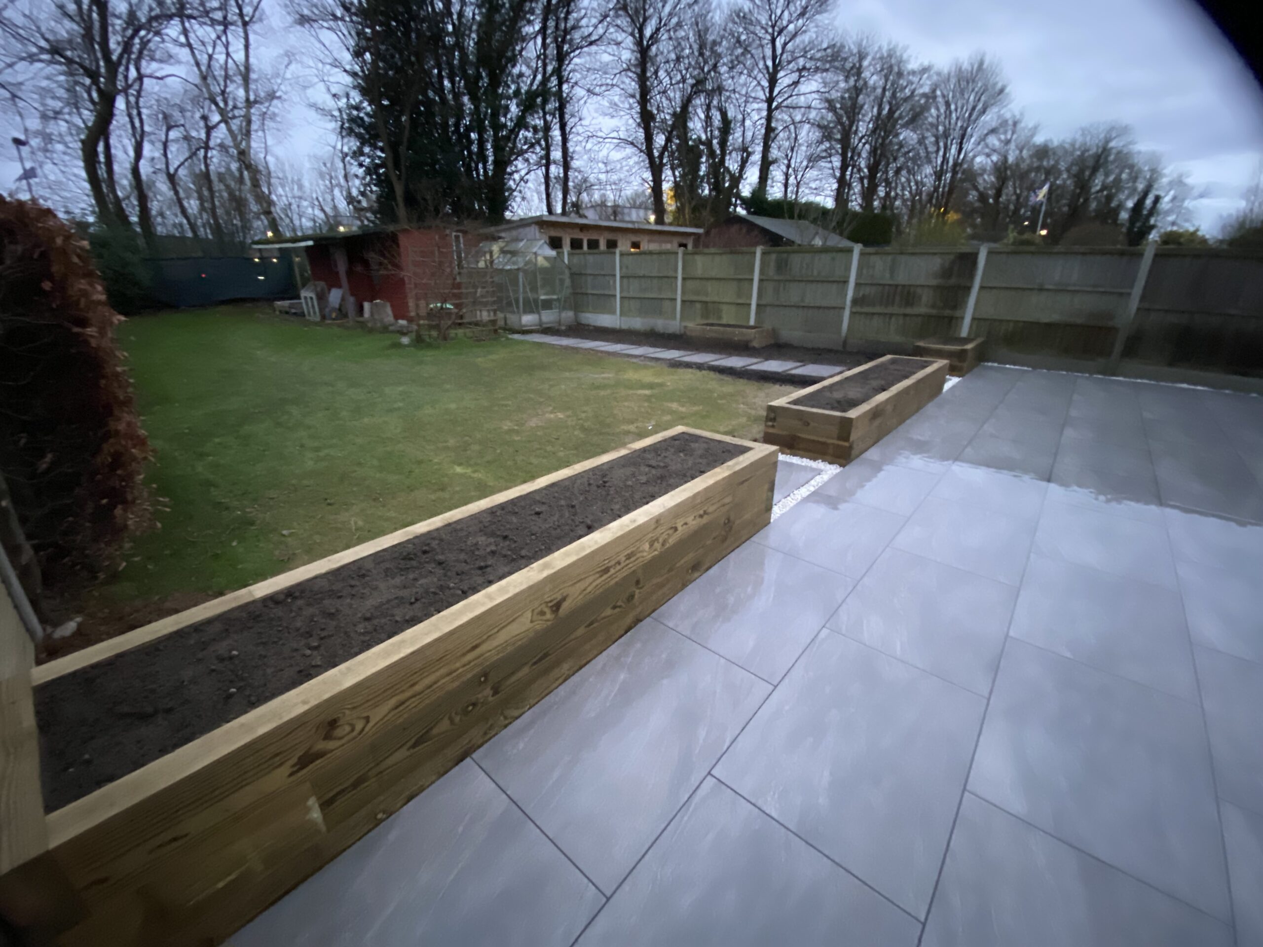 Sleeper raised beds and planters in Maidstone beside a porcelain patio