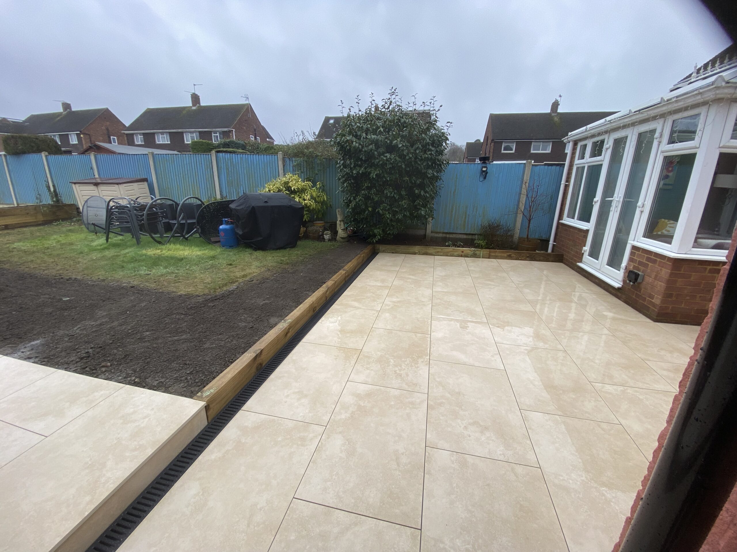 Beige porcelain patio with drainage channel installed in Maidstone
