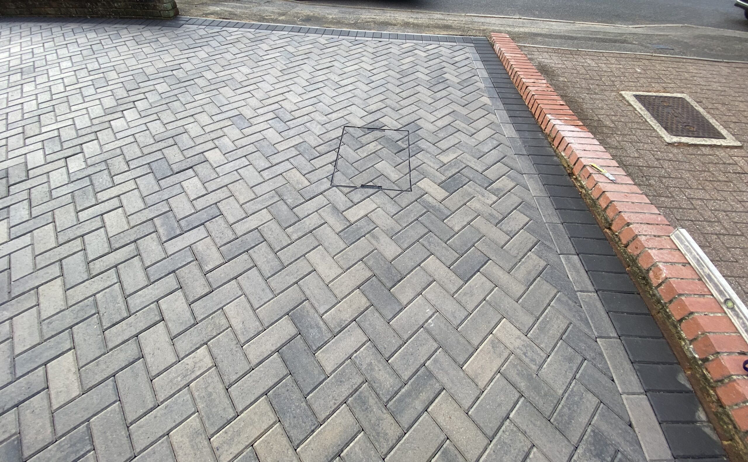 Grey block paved driveway with dark contrasting border