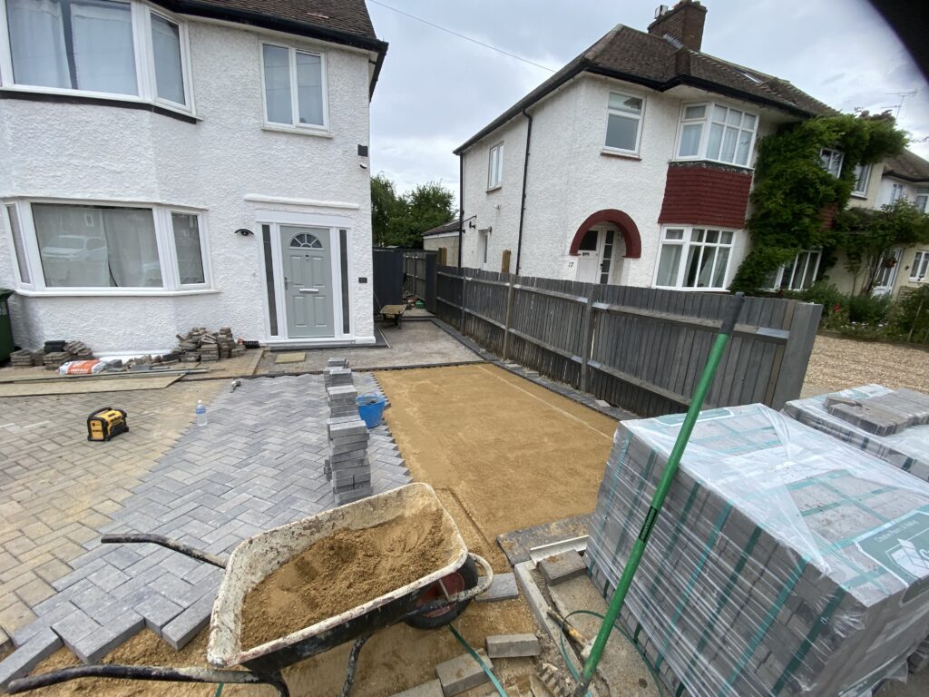 Block paved driveway installation with paving being laid on prepared ground